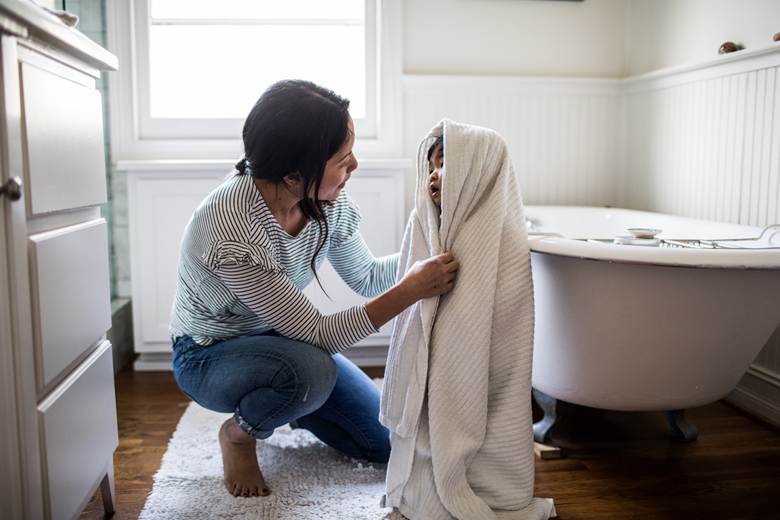 Woman toweling child after bath