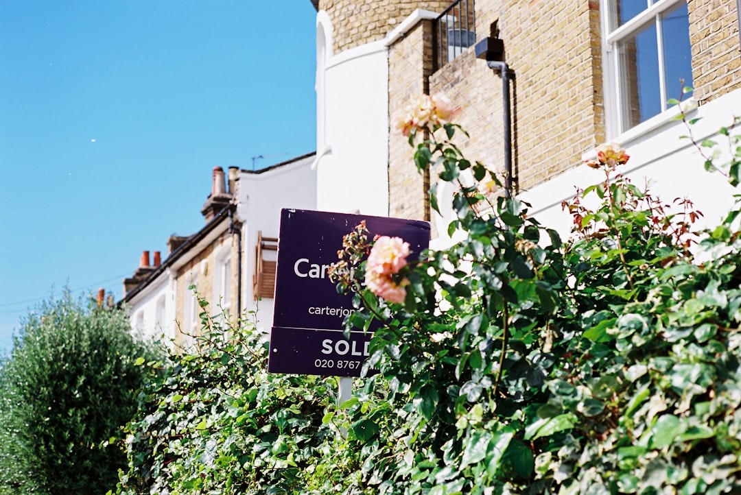A for-sale sign in front of a suburban house